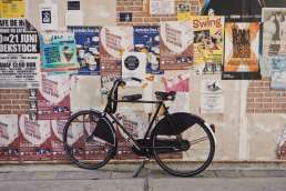 Bicycle against poster covered wall
