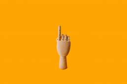 Wooden hand against yellow background