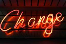 word 'change' written in red neon lights