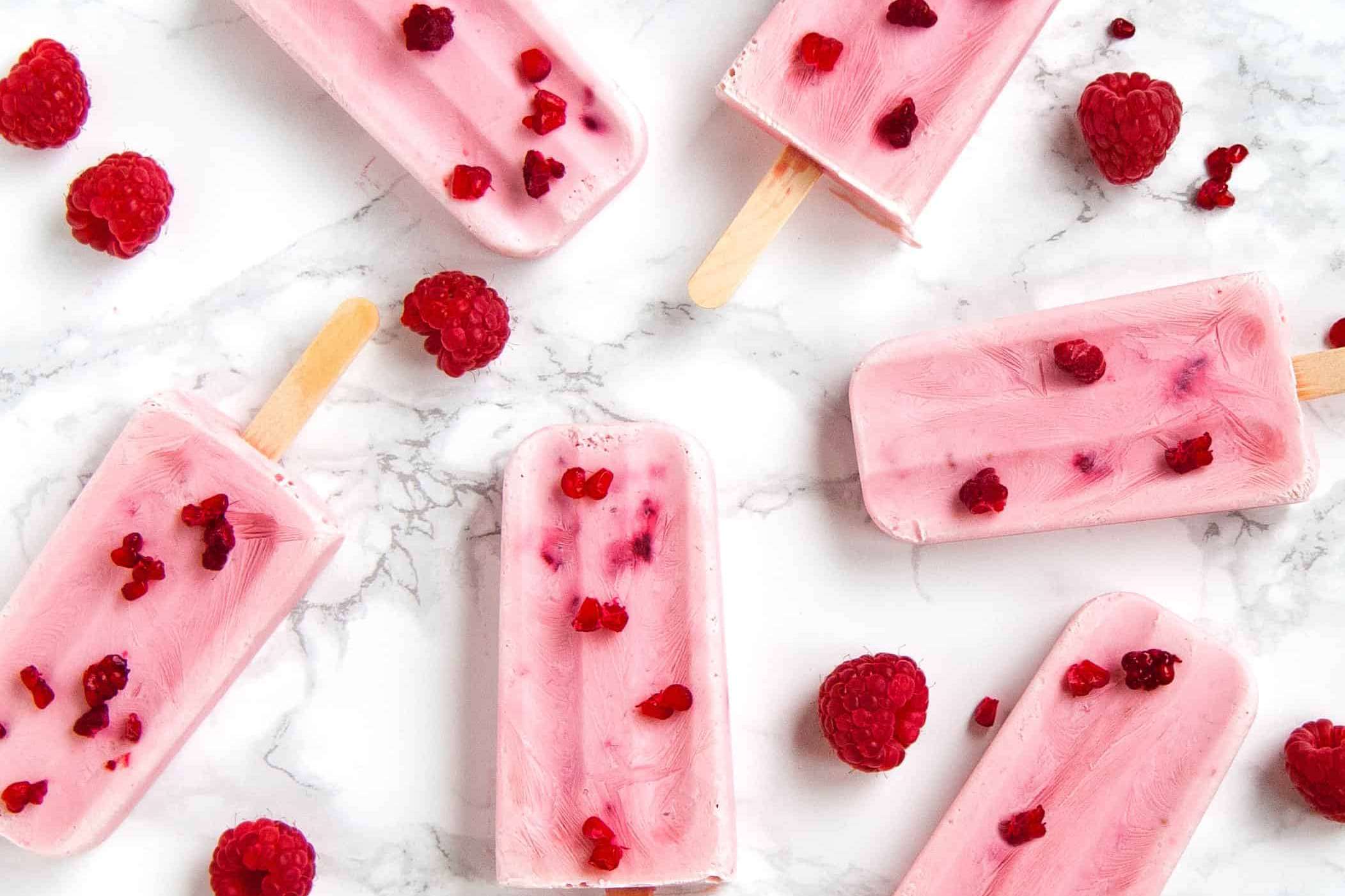 Raspberry popsicles on marble table