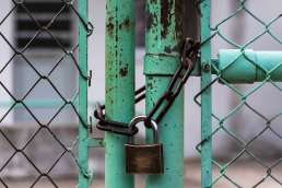 Metal fence locked with lock and chain