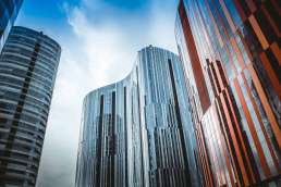 Tall glass windowed buildings and blue cloudy sky