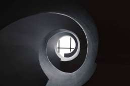 Spiral tube that leads to window with light behind it