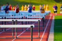 Picture of hurdles with people in background running towards them
