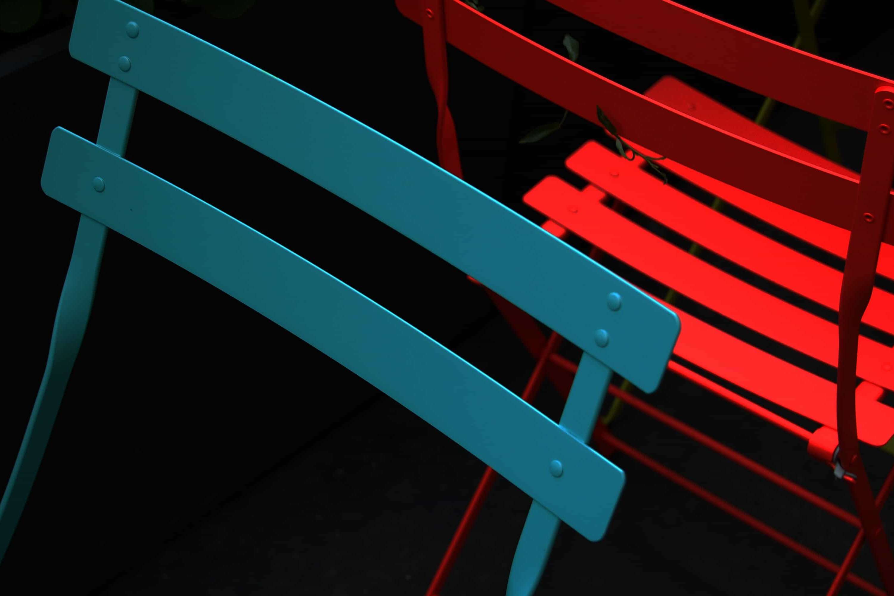 Red and blue chairs against black background