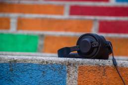 Headphones with multi-colored painted bricks in background