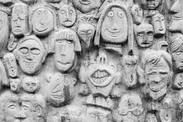 Wall of clay sculpted faces