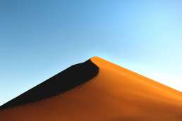 Photo of sand dune against blue sky