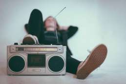 Person laying down with foot propped up on boombox