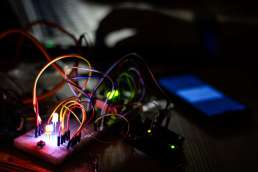 Multi-colored wires plugged into a glowing circuit board