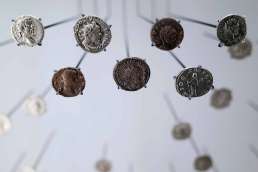 A variety of old coins hanging from wires