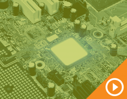 Close up photo of a circuit board behind a green transparency with a white play button on an orange triangle in the bottom right corner