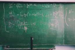 Green chalkboard with equations written on it