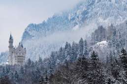 castle beneath a mountain in winter