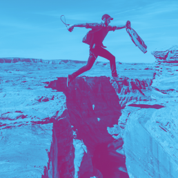 Blue and purple photo of man jumping over gap in mountain