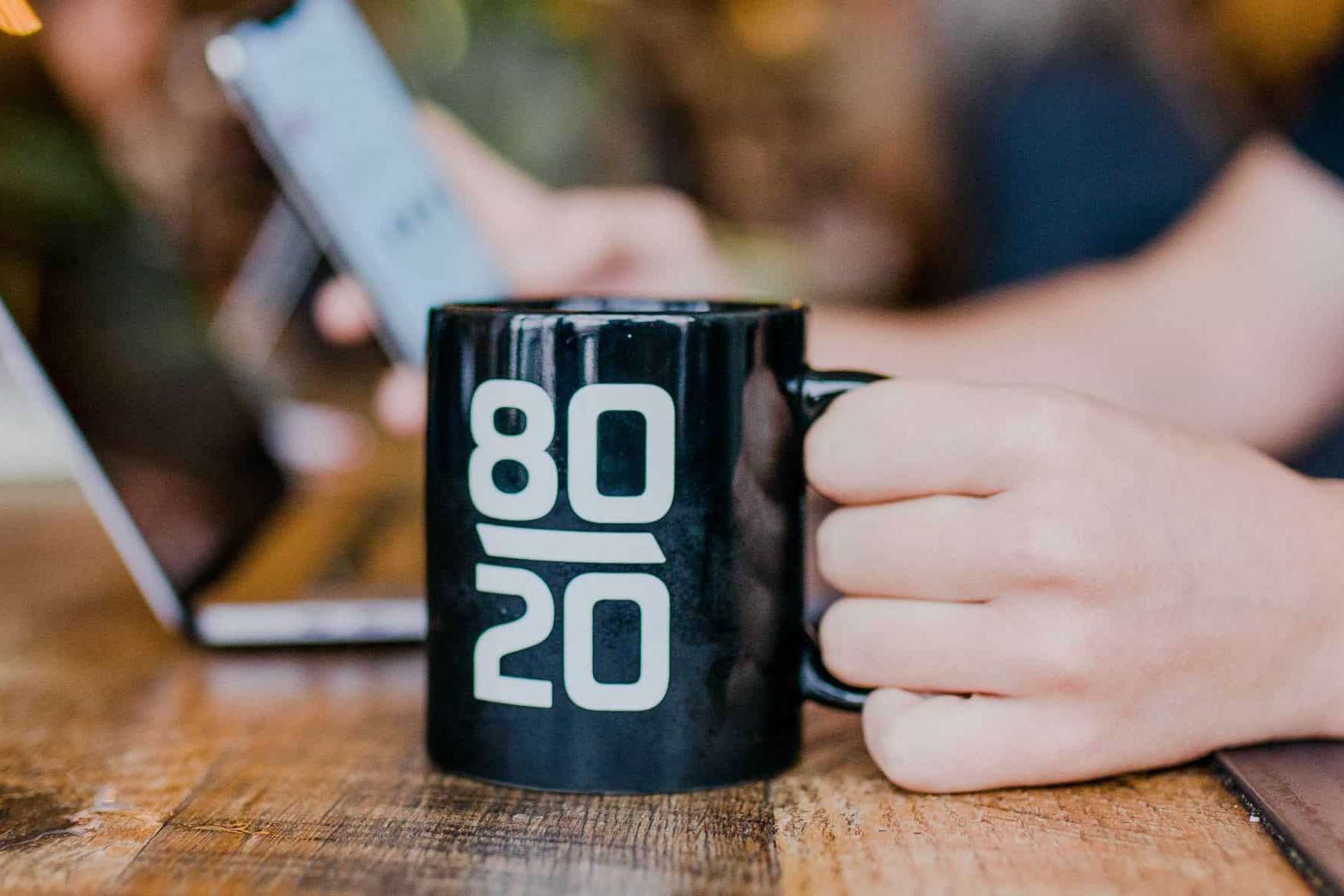 mug with 80/20 in front of laptop