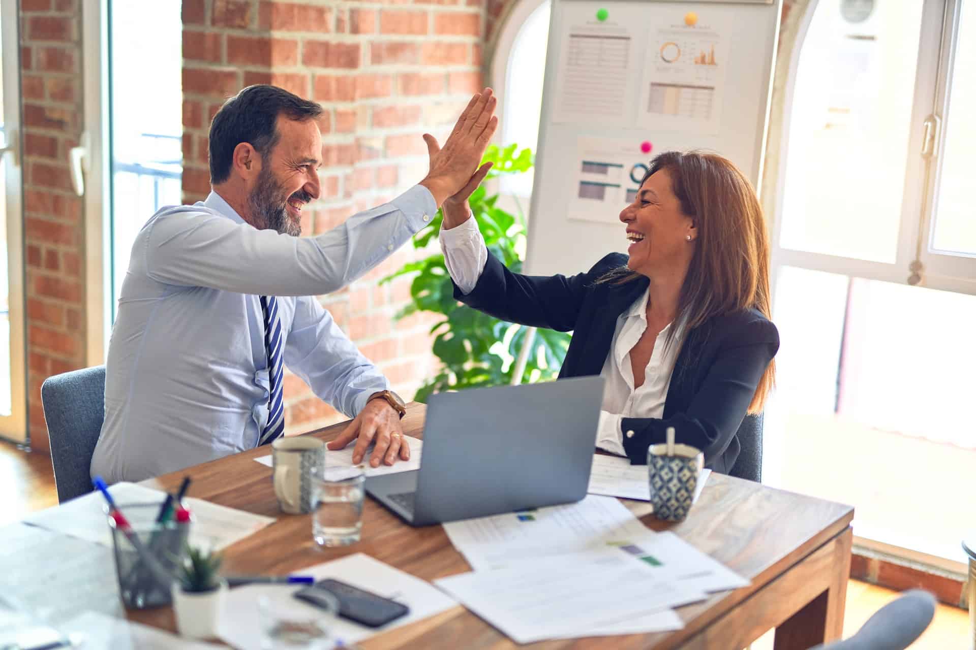 male and female in office high fiving