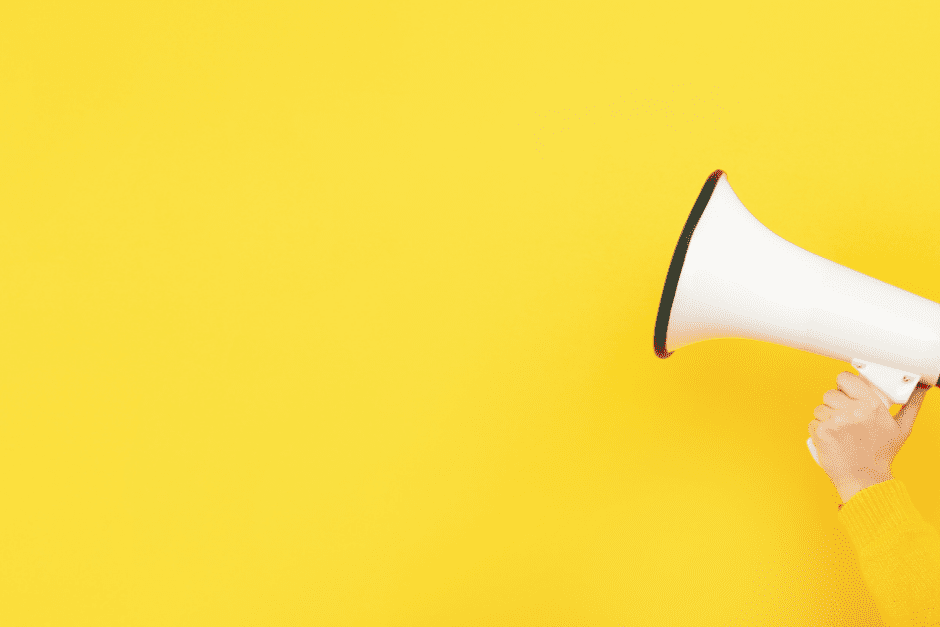 yellow background with hand holding megaphone